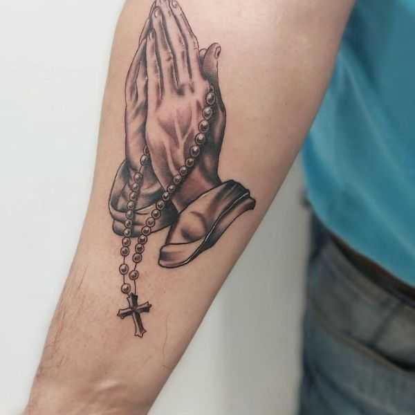 Biblical tattoo with praying hands and cross